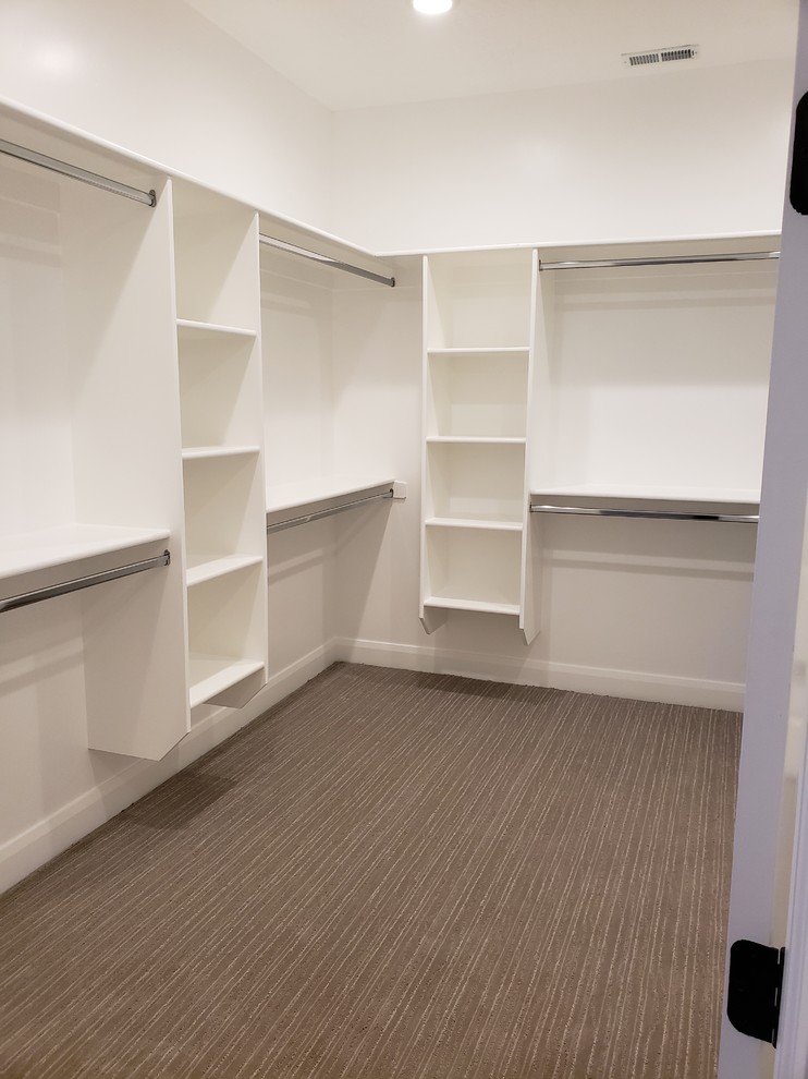 Walk-in closet - huge craftsman gender-neutral carpeted and beige floor walk-in closet idea in Other with open cabinets and white cabinets