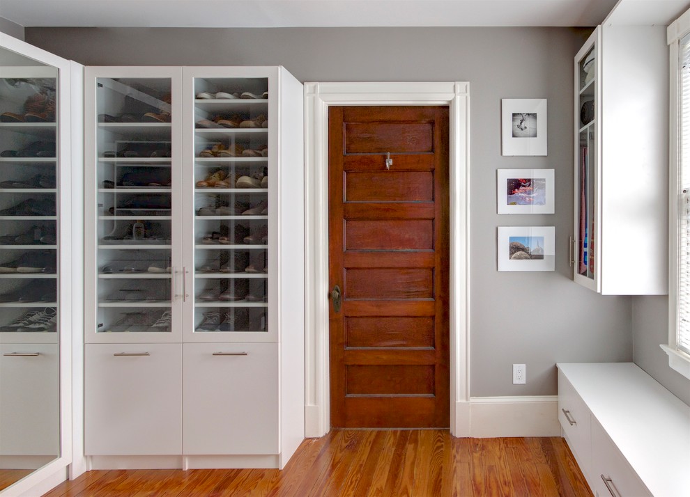 Ejemplo de armario vestidor unisex tradicional renovado de tamaño medio con armarios tipo vitrina, puertas de armario blancas, suelo de madera en tonos medios y suelo marrón