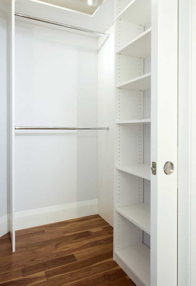 Idee per una piccola cabina armadio unisex classica con ante lisce, ante bianche e pavimento in legno massello medio