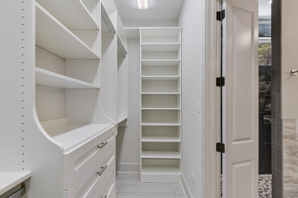 Imagen de armario vestidor unisex clásico de tamaño medio con armarios estilo shaker, puertas de armario blancas, suelo de baldosas de porcelana y suelo gris