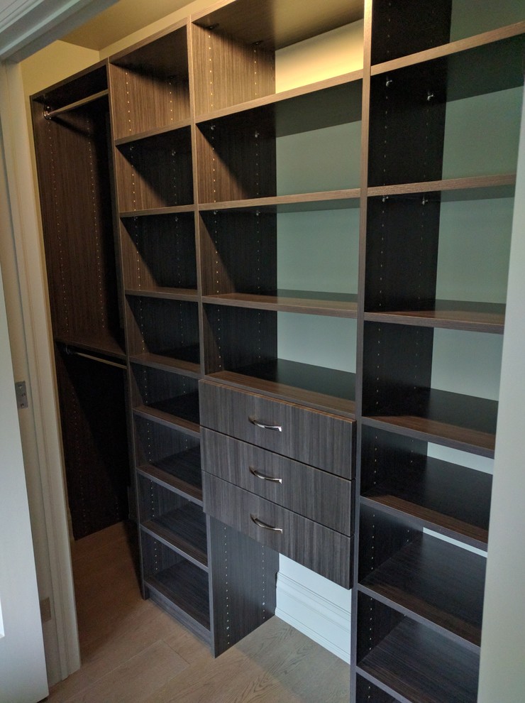 Medium sized modern standard wardrobe for men in Toronto with open cabinets, light hardwood flooring and grey cabinets.