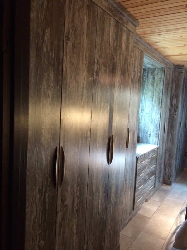 Foto de armario unisex rústico pequeño con armarios con paneles lisos y puertas de armario de madera en tonos medios