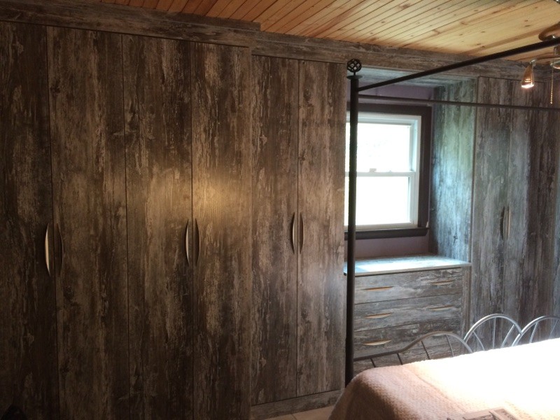 Diseño de armario unisex rural pequeño con armarios con paneles lisos y puertas de armario de madera en tonos medios
