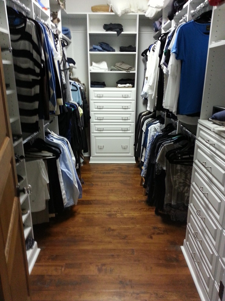 Ejemplo de armario vestidor de hombre clásico de tamaño medio con armarios con paneles con relieve, puertas de armario blancas, suelo de madera oscura y suelo marrón
