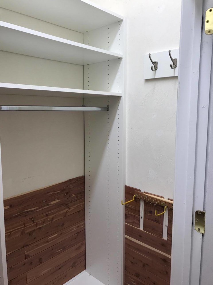 Imagen de armario vestidor de tamaño medio con armarios con paneles lisos, puertas de armario blancas, suelo de madera en tonos medios y suelo marrón