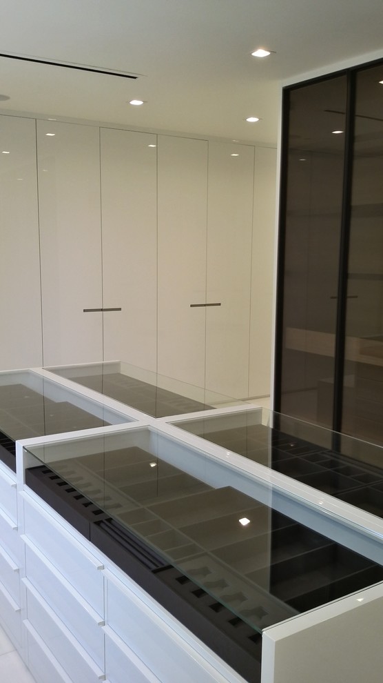 Immagine di una grande cabina armadio unisex minimalista con ante lisce, ante bianche, pavimento in marmo e pavimento bianco