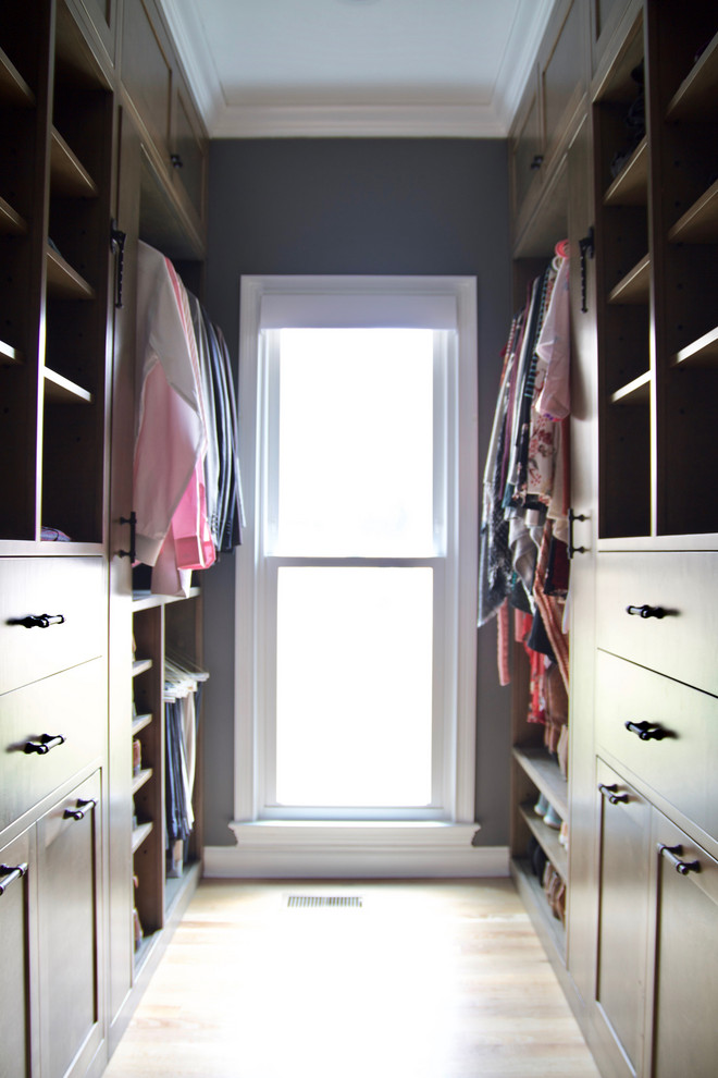 Ejemplo de armario vestidor unisex actual de tamaño medio con armarios estilo shaker, puertas de armario de madera oscura, suelo de madera en tonos medios y suelo marrón