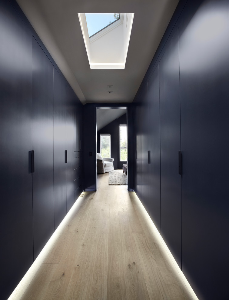 Источник вдохновения для домашнего уюта: гардеробная комната среднего размера, унисекс в современном стиле с плоскими фасадами, синими фасадами и светлым паркетным полом