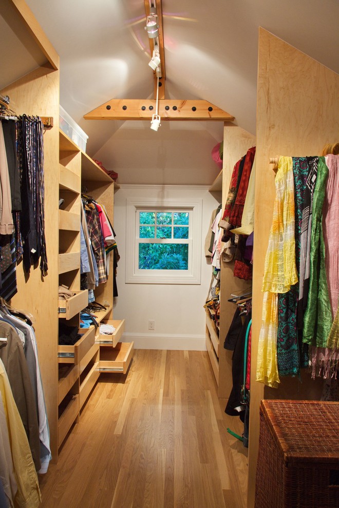 Diseño de vestidor unisex clásico de tamaño medio con armarios con paneles lisos, puertas de armario de madera clara, suelo de madera clara y suelo beige