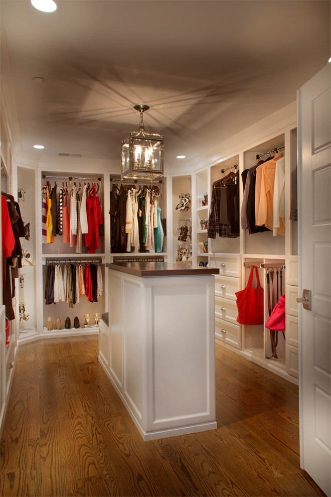 Exempel på ett stort klassiskt walk-in-closet för kvinnor, med vita skåp, mellanmörkt trägolv och luckor med infälld panel