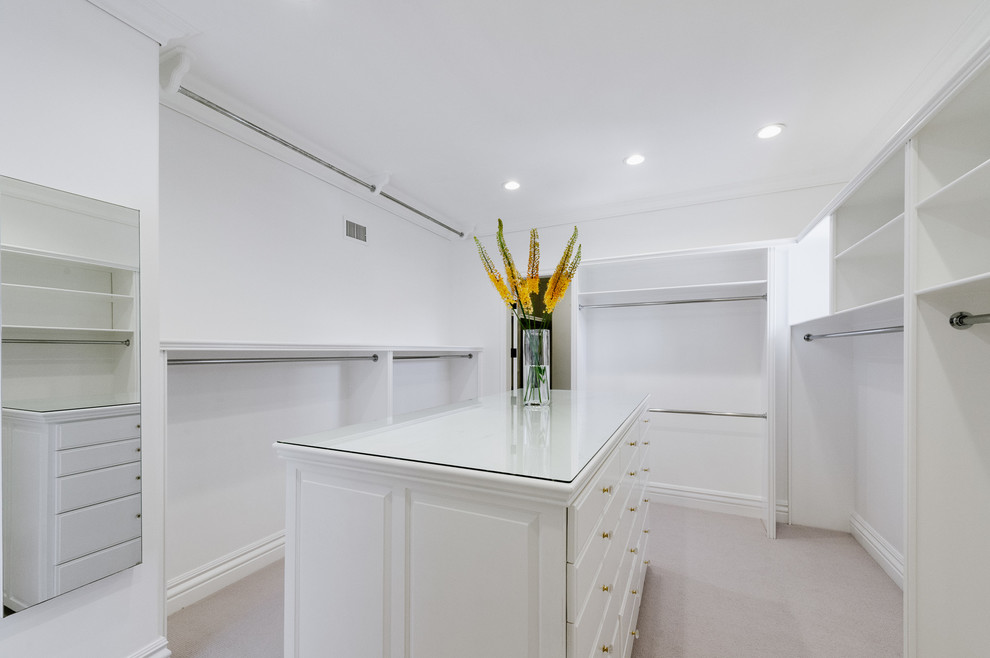 Example of a huge transitional gender-neutral dressing room design in Los Angeles with white cabinets and raised-panel cabinets