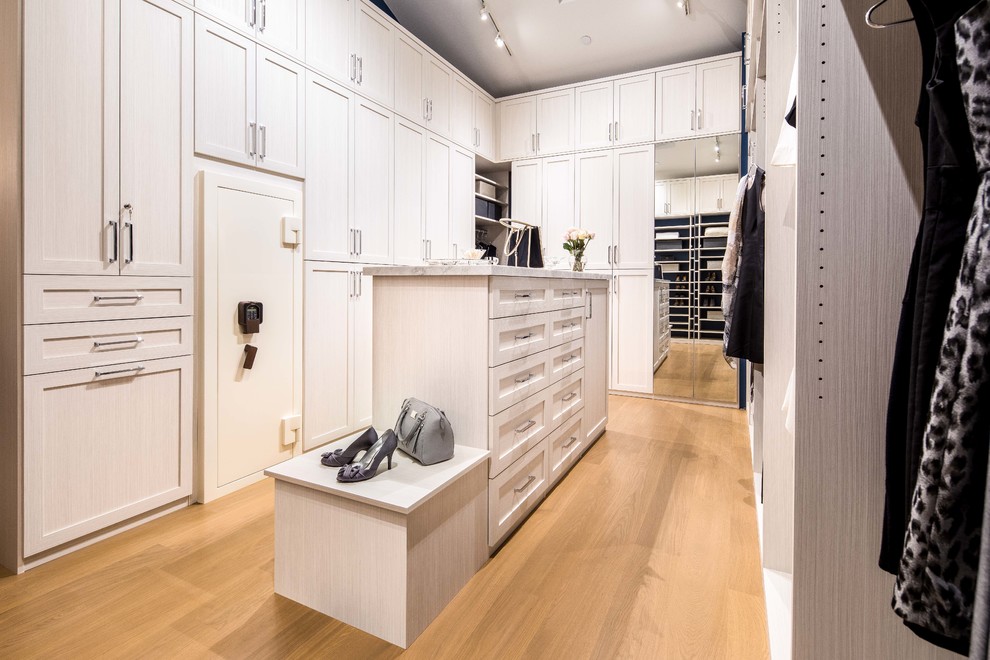 Inspiration för stora moderna walk-in-closets för kvinnor, med luckor med upphöjd panel, vita skåp, ljust trägolv och beiget golv