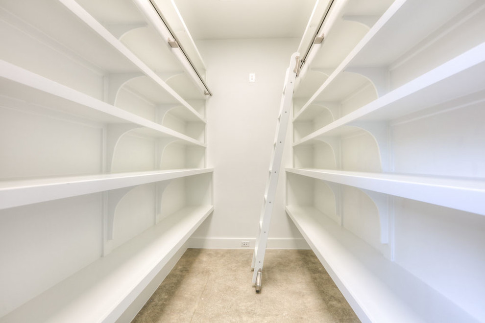 Ejemplo de armario vestidor unisex moderno de tamaño medio con armarios abiertos, puertas de armario blancas, suelo de cemento y suelo beige