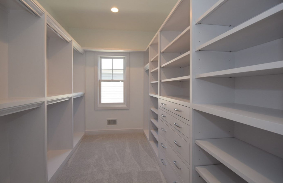 Walk-in closet - huge country gender-neutral carpeted and gray floor walk-in closet idea in Detroit with yellow cabinets