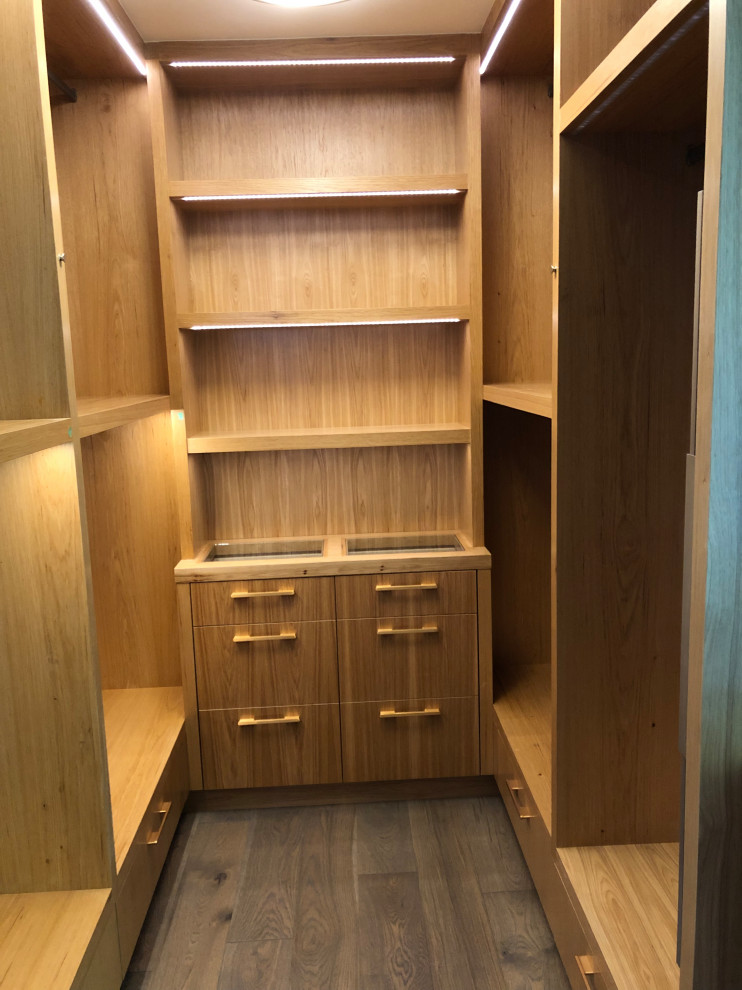 Ispirazione per una grande cabina armadio minimalista con ante lisce, ante marroni, parquet chiaro e pavimento marrone