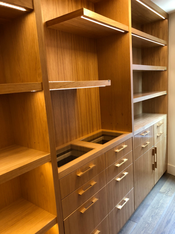Inspiration for a large modern walk-in wardrobe in Calgary with flat-panel cabinets, brown cabinets, light hardwood flooring and brown floors.