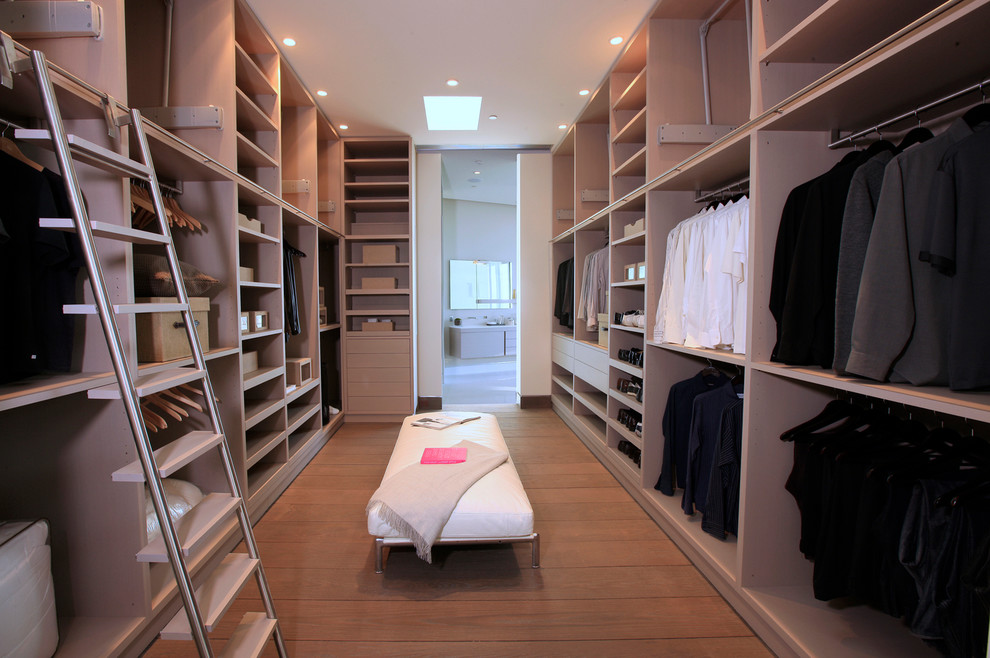 Example of a trendy men's dressing room design in Los Angeles with open cabinets and light wood cabinets