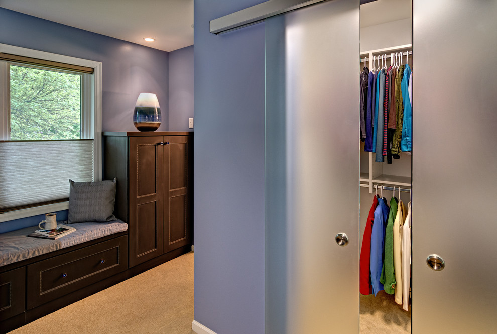 Ejemplo de vestidor unisex actual grande con armarios con paneles empotrados, puertas de armario de madera en tonos medios y moqueta