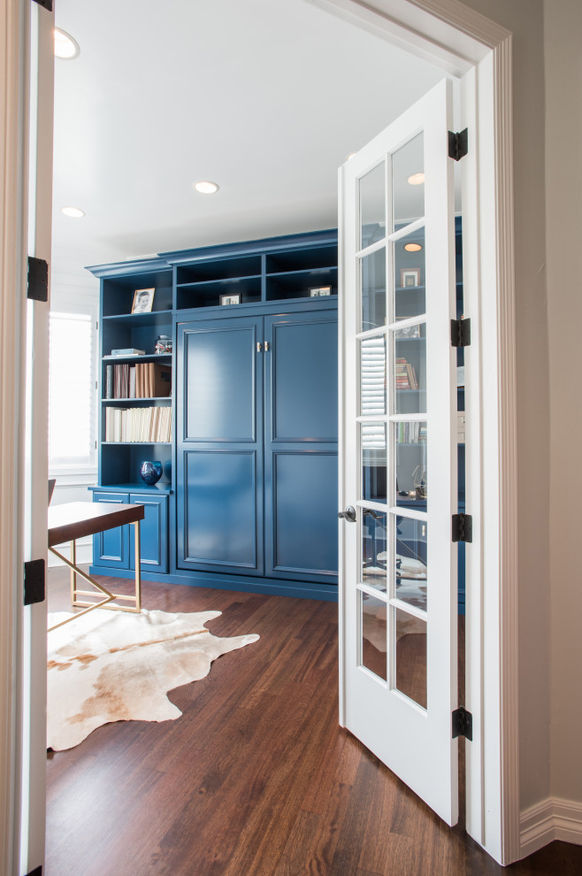Idée de décoration pour une armoire encastrée tradition de taille moyenne et neutre avec un placard avec porte à panneau encastré, des portes de placard bleues, sol en stratifié et un sol marron.