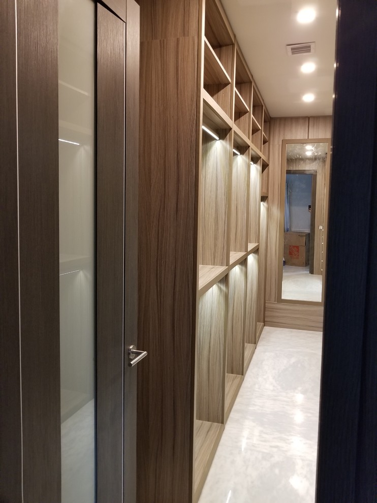 Diseño de armario vestidor unisex tradicional renovado grande con armarios abiertos, puertas de armario de madera clara, suelo de mármol y suelo blanco