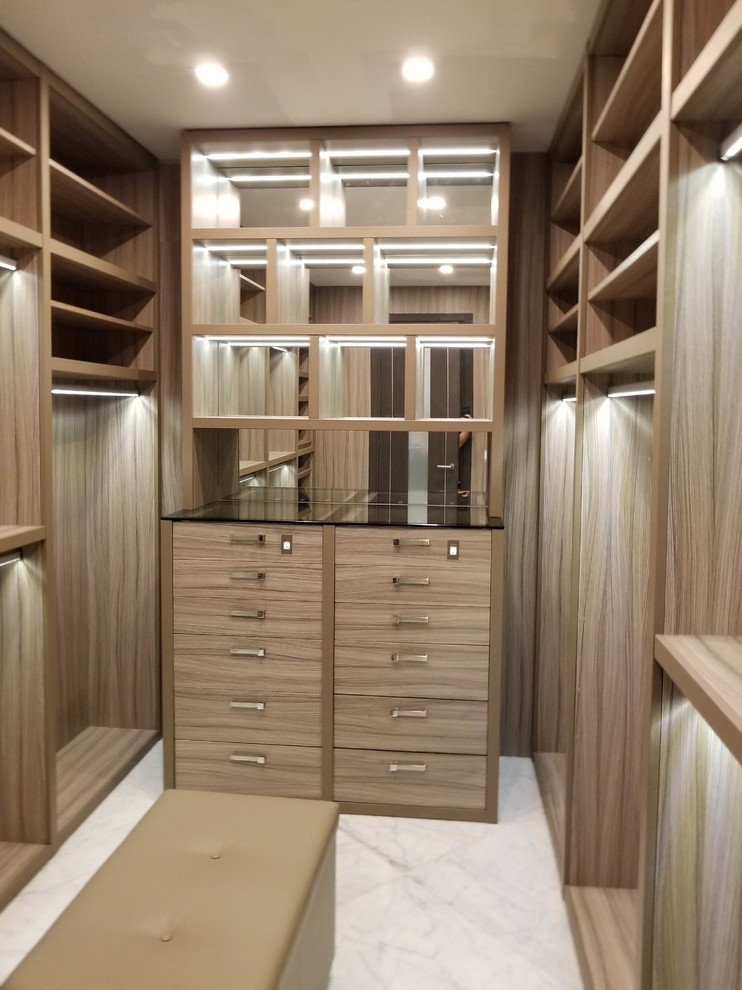 Imagen de armario vestidor unisex clásico renovado grande con armarios abiertos, puertas de armario de madera clara, suelo de mármol y suelo blanco