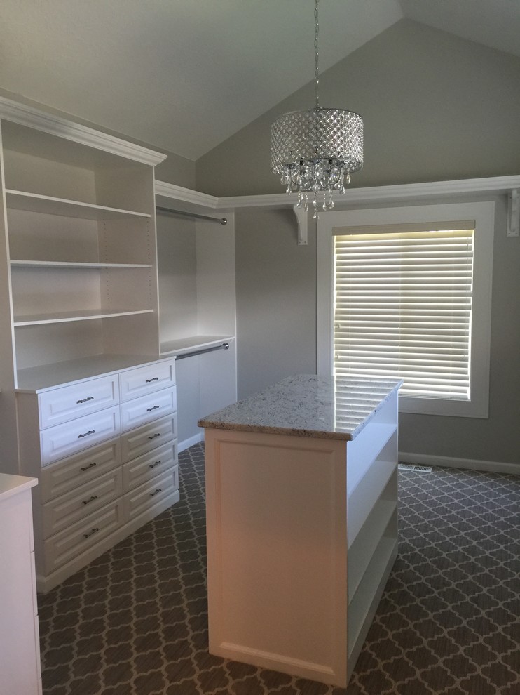 Large vintage walk-in wardrobe in Boise with raised-panel cabinets, white cabinets, carpet and grey floors.
