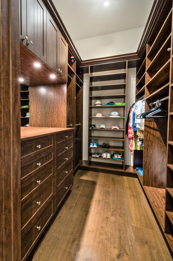Large classic gender neutral walk-in wardrobe in Miami with dark wood cabinets and dark hardwood flooring.
