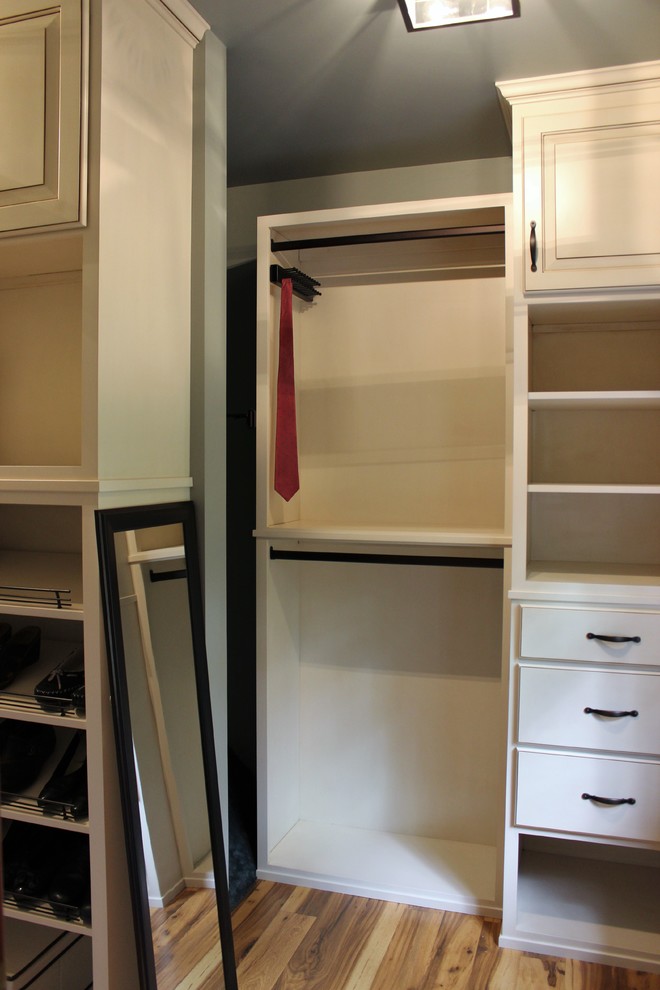 Foto de armario vestidor unisex tradicional renovado de tamaño medio con armarios con paneles con relieve, puertas de armario blancas y suelo de madera en tonos medios
