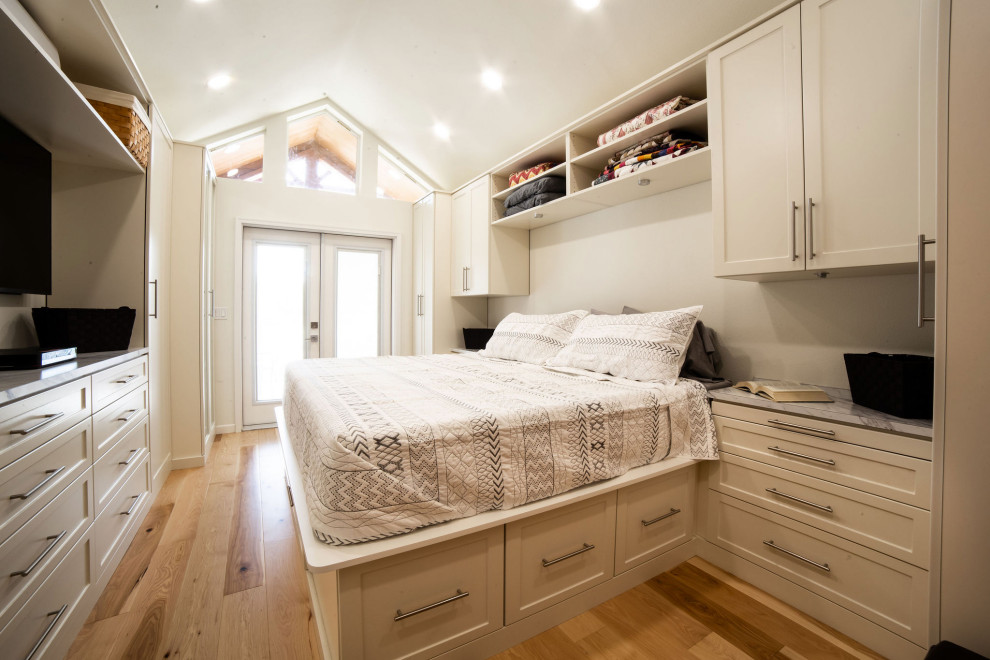 Idee per una cabina armadio unisex tradizionale di medie dimensioni con ante in stile shaker, ante beige, pavimento in legno massello medio e pavimento giallo