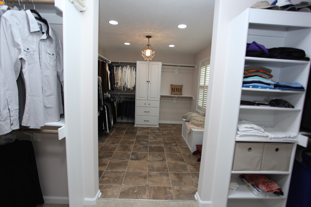 Foto på ett mellanstort shabby chic-inspirerat walk-in-closet för könsneutrala, med luckor med upphöjd panel, vita skåp, skiffergolv och brunt golv