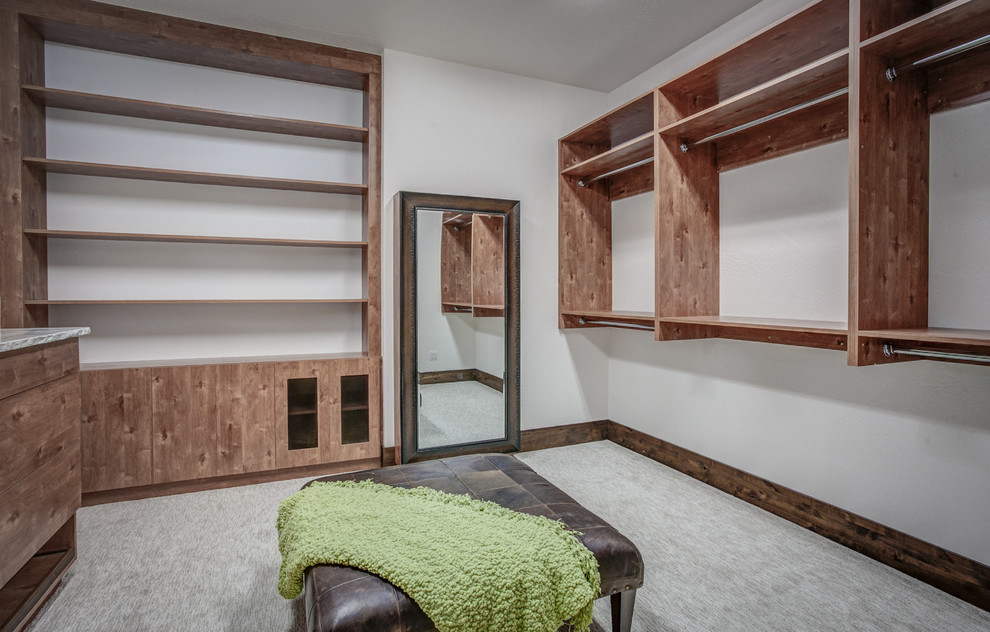 Idée de décoration pour un grand dressing room chalet en bois brun neutre avec un placard à porte plane et moquette.