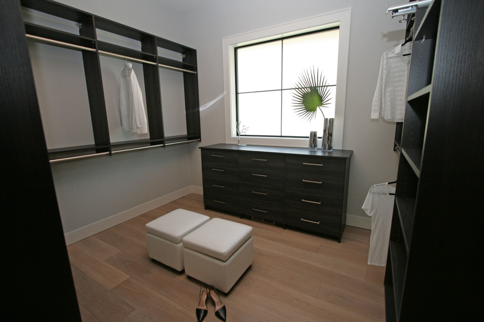 Inspiration for a medium sized traditional gender neutral walk-in wardrobe in Seattle with flat-panel cabinets, black cabinets, light hardwood flooring and grey floors.