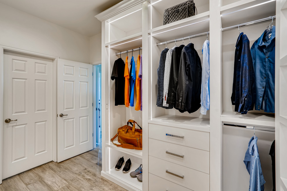 Foto di una cabina armadio unisex minimalista di medie dimensioni con ante lisce, ante bianche, parquet chiaro e pavimento beige