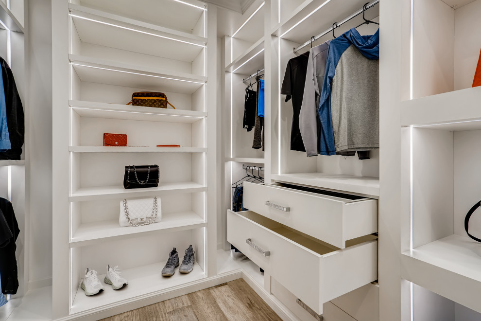 Exempel på ett mellanstort modernt walk-in-closet för könsneutrala, med släta luckor, vita skåp, ljust trägolv och beiget golv