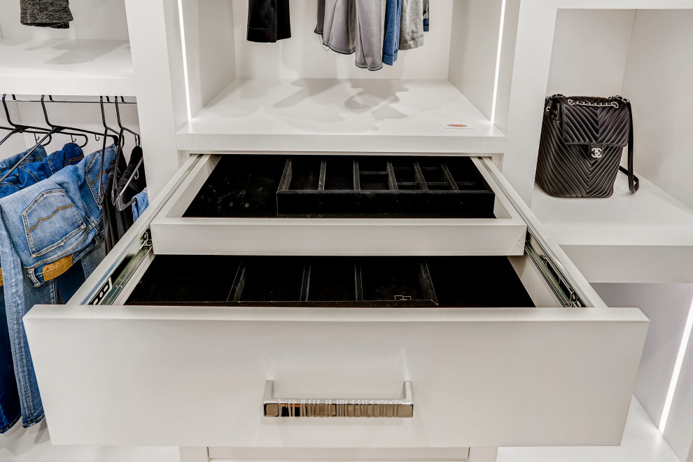 Inspiration for a mid-sized modern gender-neutral light wood floor and beige floor walk-in closet remodel in Denver with flat-panel cabinets and white cabinets