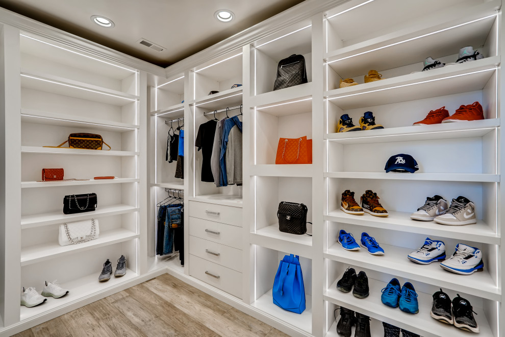 Diseño de armario vestidor actual de tamaño medio con armarios abiertos, puertas de armario blancas, suelo de madera clara y suelo beige