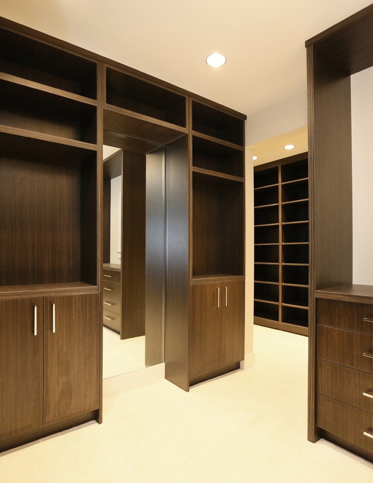 Modelo de armario vestidor de hombre de estilo zen extra grande con armarios abiertos, puertas de armario de madera en tonos medios y moqueta