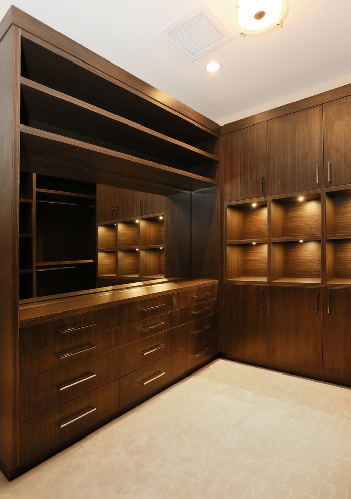 Photo of an expansive world-inspired walk-in wardrobe for men in Vancouver with open cabinets, dark wood cabinets and carpet.