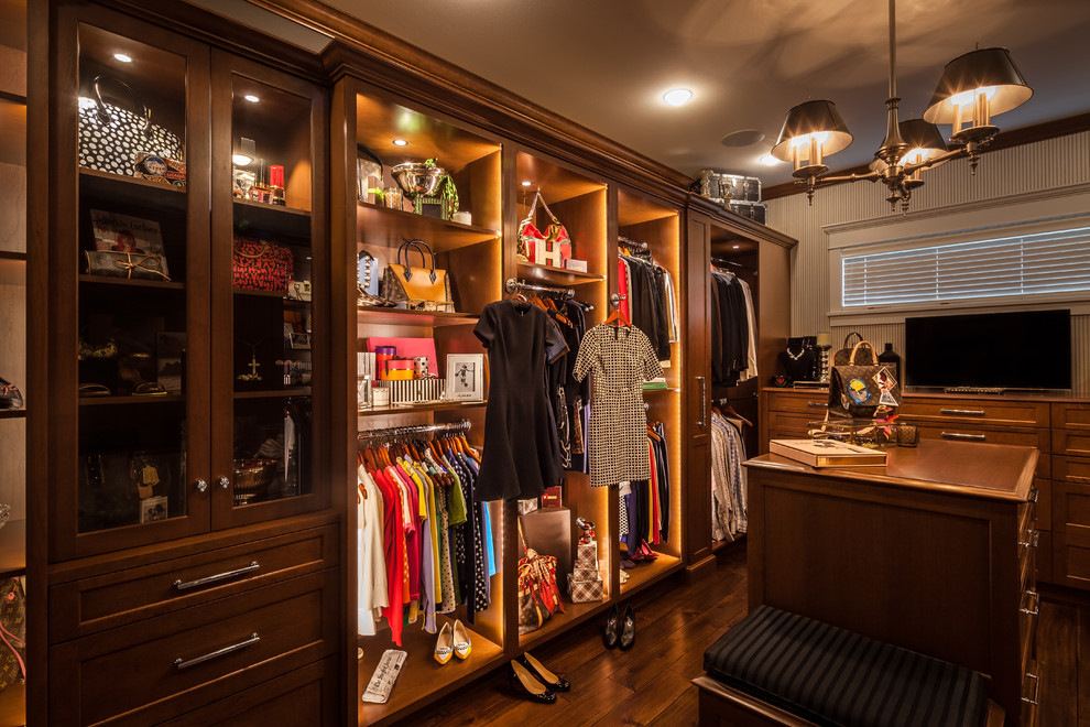 Inspiration pour un grand dressing room traditionnel en bois brun pour une femme avec un placard avec porte à panneau encastré et parquet foncé.