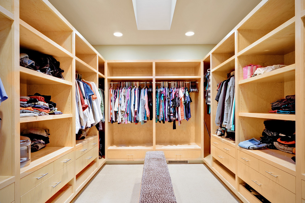 Example of a huge trendy gender-neutral carpeted dressing room design in Seattle with open cabinets and light wood cabinets