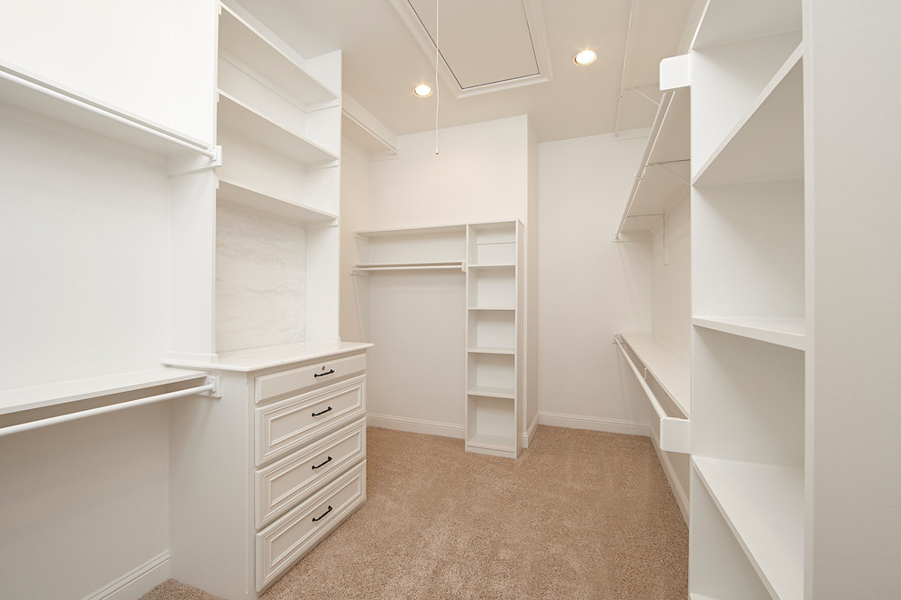 На фото: гардеробная комната унисекс в стиле неоклассика (современная классика) с фасадами с утопленной филенкой, белыми фасадами, ковровым покрытием и бежевым полом