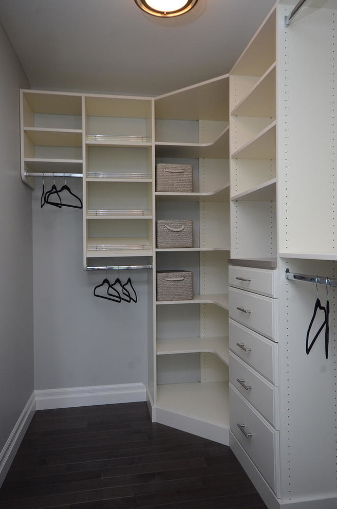 Foto de armario vestidor unisex minimalista con armarios abiertos, puertas de armario blancas y suelo de madera oscura