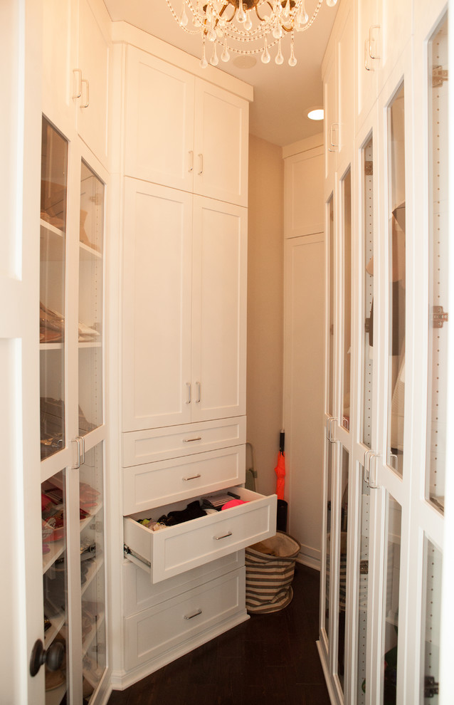Bild på ett mellanstort walk-in-closet för könsneutrala, med vita skåp, luckor med glaspanel och mörkt trägolv