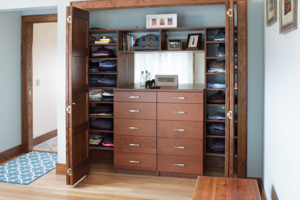 Foto de armario unisex contemporáneo de tamaño medio con armarios con paneles lisos, puertas de armario de madera oscura y suelo de madera clara