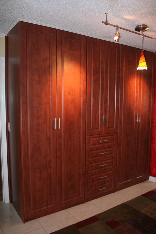 Пример оригинального дизайна: гардеробная комната среднего размера в классическом стиле с фасадами с выступающей филенкой, темными деревянными фасадами и полом из керамической плитки для мужчин