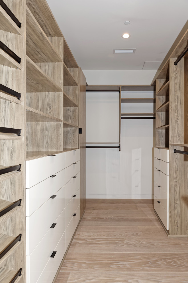 This is an example of a medium sized contemporary walk-in wardrobe in San Francisco with flat-panel cabinets, white cabinets, light hardwood flooring and brown floors.