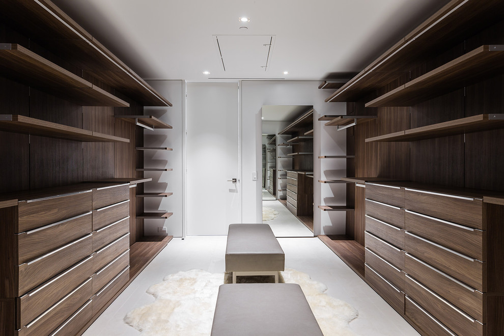 Imagen de armario vestidor unisex actual grande con armarios con paneles lisos, puertas de armario de madera clara, suelo de baldosas de cerámica y suelo beige
