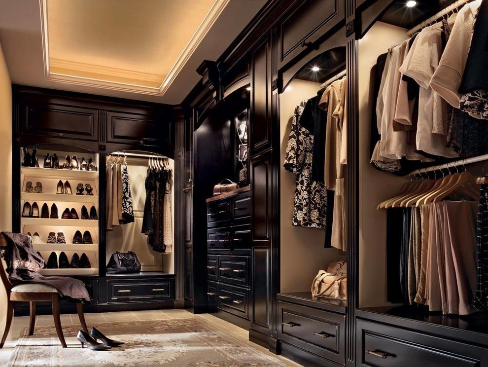 На фото: огромная гардеробная комната унисекс в классическом стиле с темными деревянными фасадами, полом из керамической плитки и фасадами с выступающей филенкой