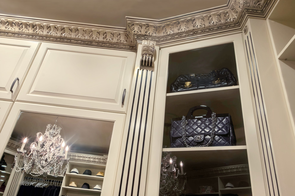 Foto de armario vestidor de mujer clásico grande con armarios con paneles con relieve, puertas de armario beige y suelo de madera en tonos medios