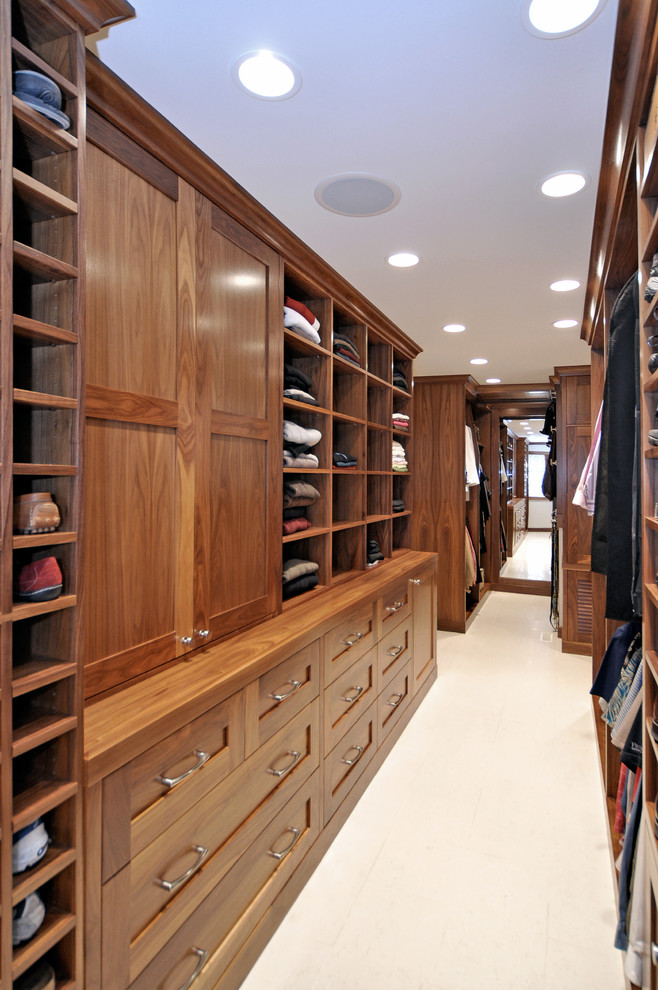 Diseño de armario y vestidor clásico renovado con armarios estilo shaker, puertas de armario de madera oscura y suelo de baldosas de porcelana